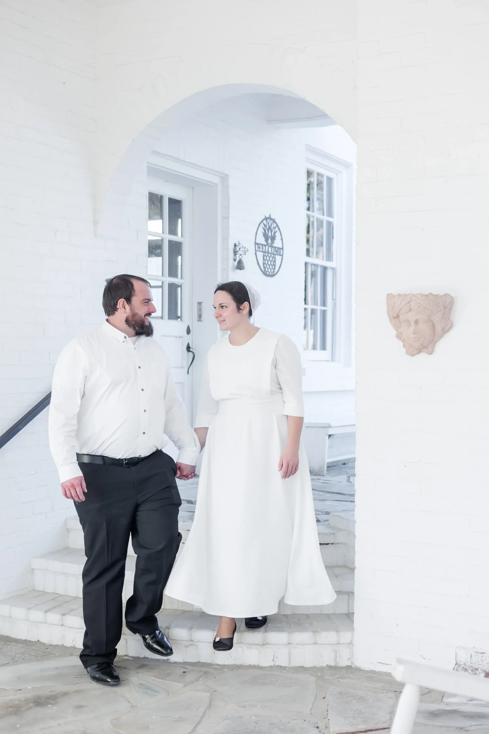 bride and groom walking down white outdoor stairs